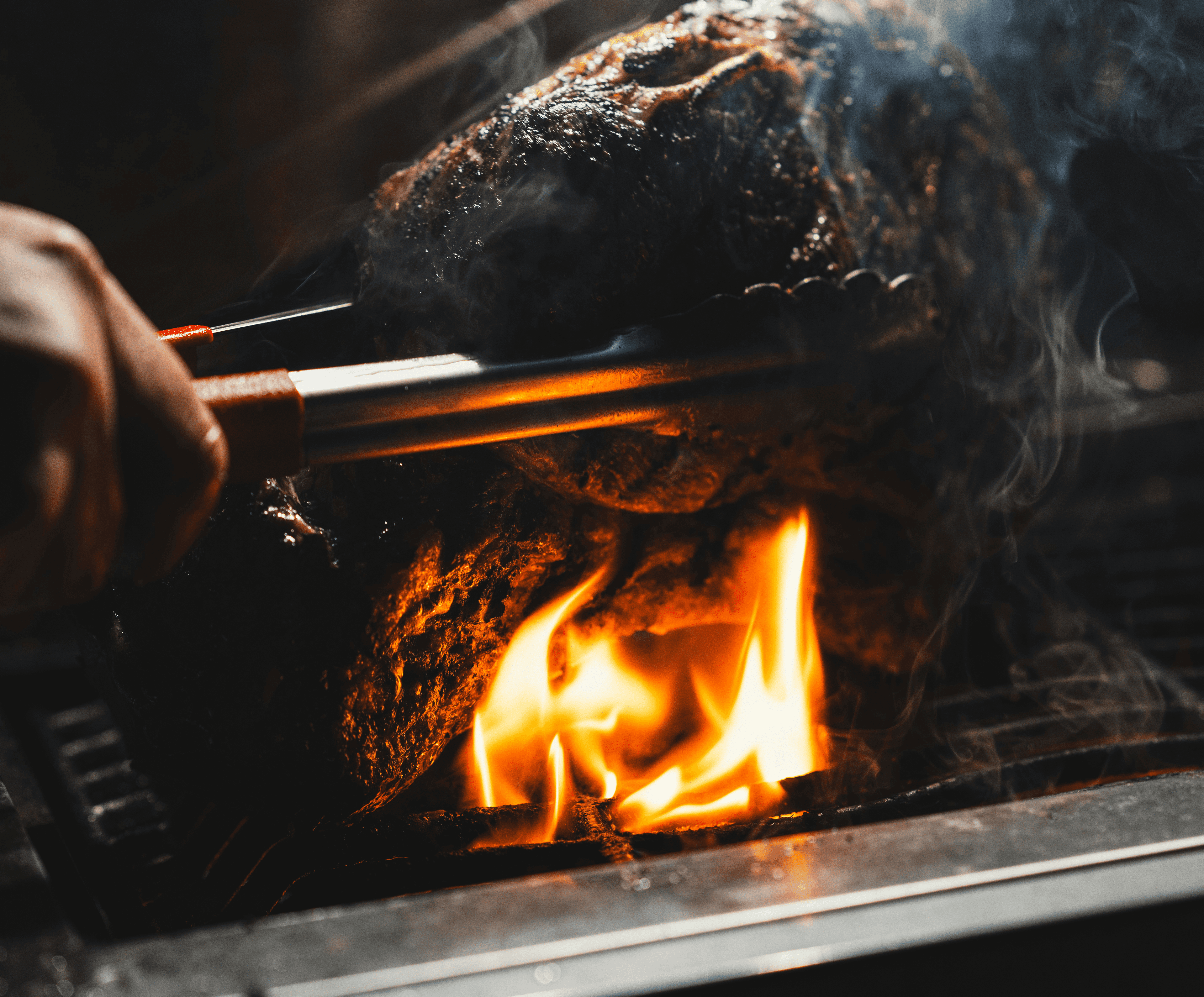 Tomahawk steak being flame‑grilled over open fire